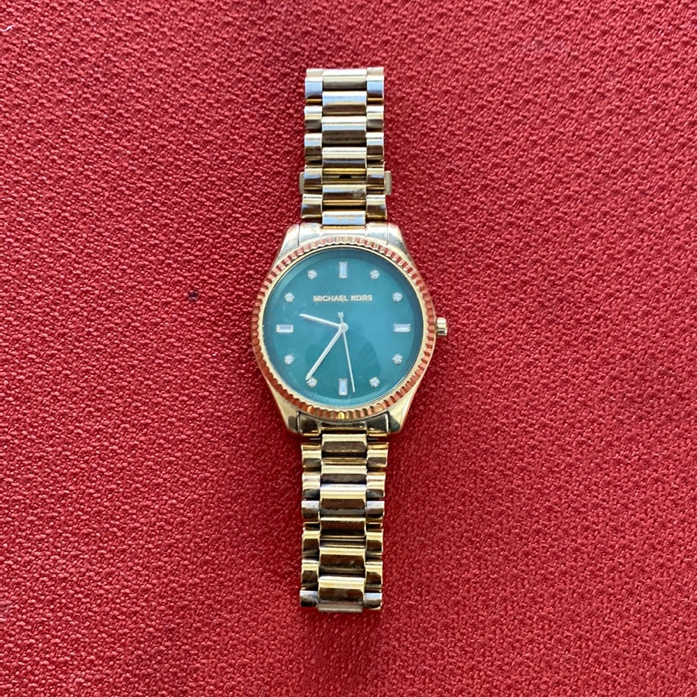 Women’s gold Michael Kors watch.